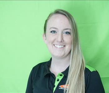 Female employee with blonde hair in front of green background